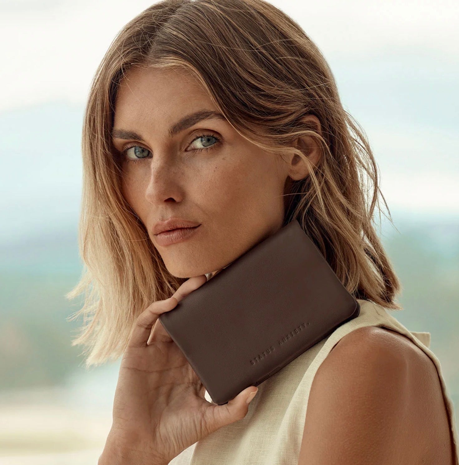 Woman holding brown leather wallet, stylish everyday accessory for confident fashion