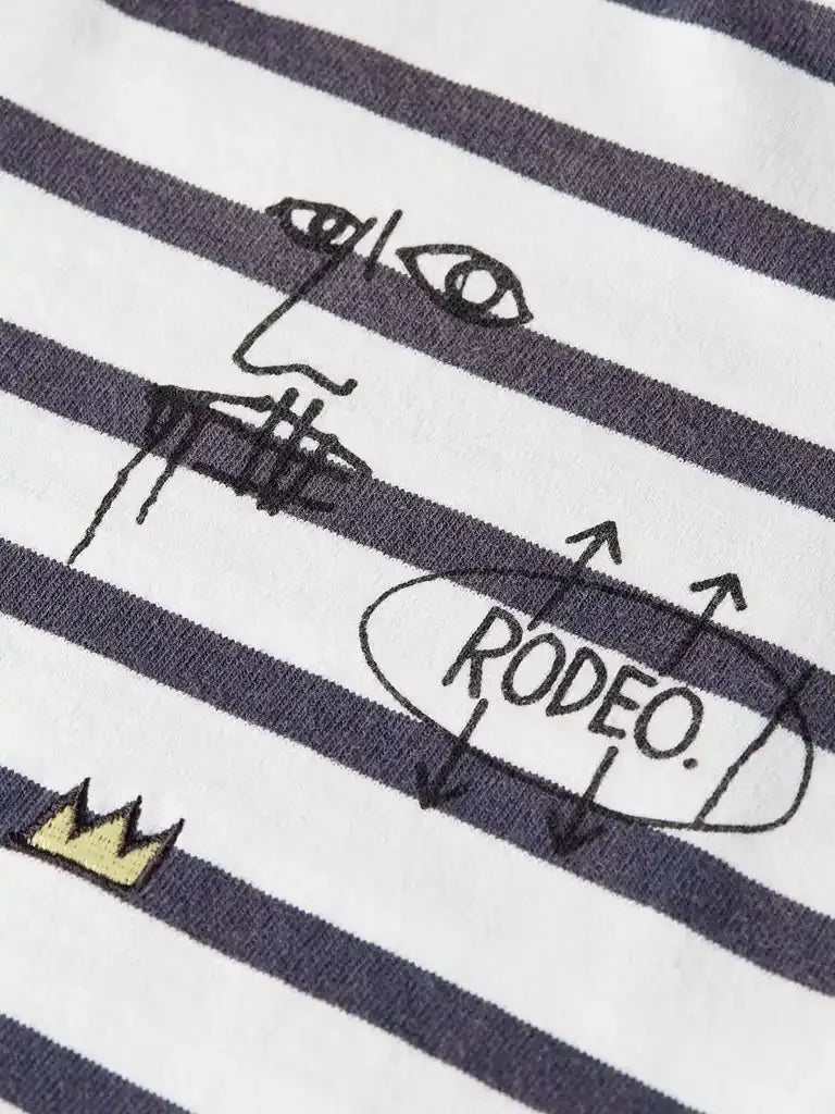 Striped women's top with 'RODEO.' graphic, abstract face, and gold crown detail