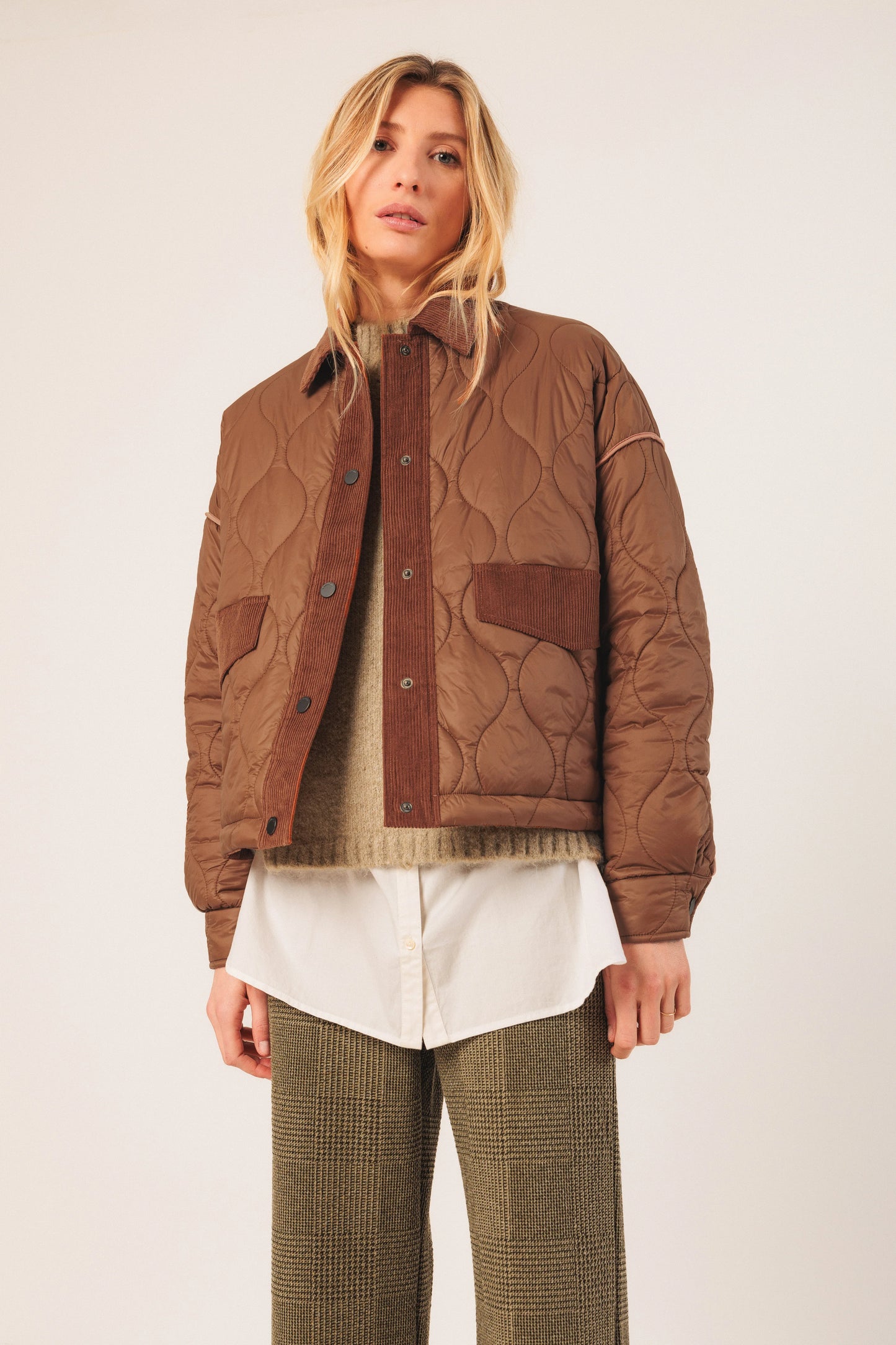 Brown quilted jacket with corduroy accents, styled with white shirt and tweed pants