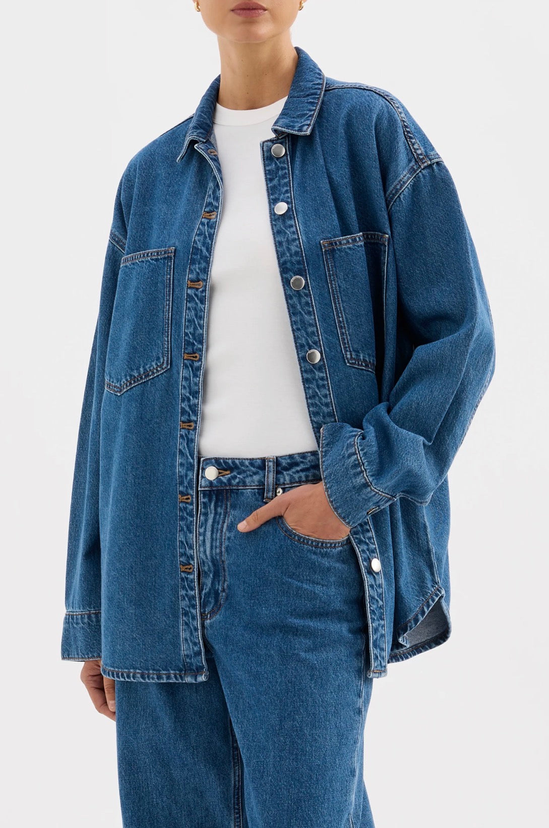 Oversized denim shirt jacket with front pockets, paired with matching jeans and white tee for women's fashion