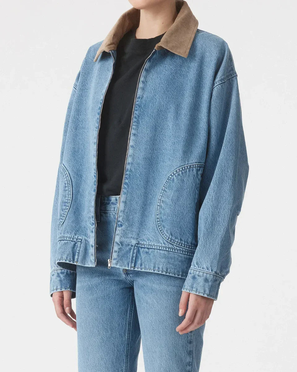 Woman wearing a blue denim jacket with tan corduroy collar and matching jeans