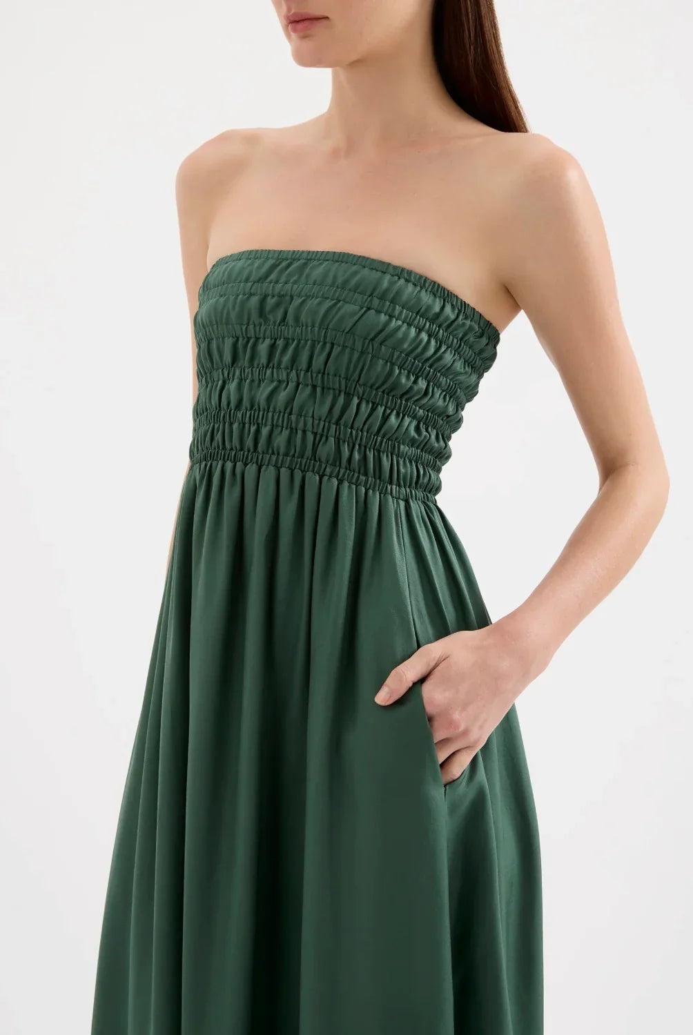 Woman wearing a strapless green gathered bodice dress with pocket, modern fashion style