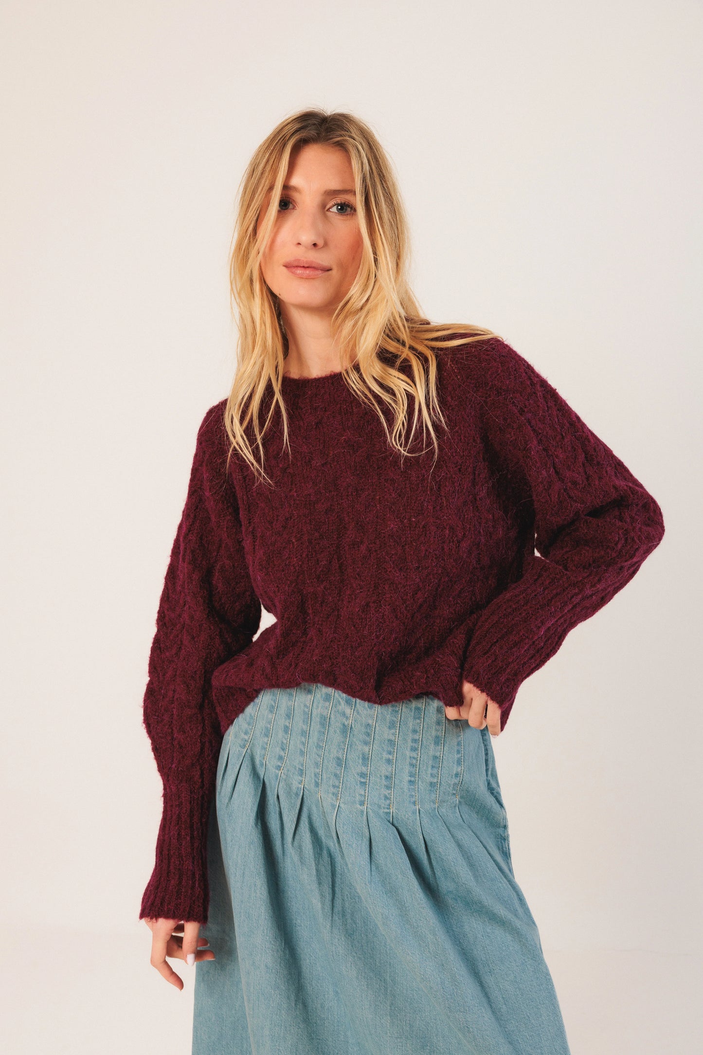 Burgundy cable knit sweater paired with light blue pleated denim skirt for women's fashion