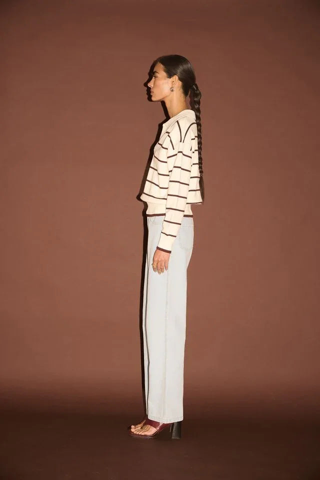 Woman in striped long-sleeve top and wide-leg jeans, side profile, fashion outfit