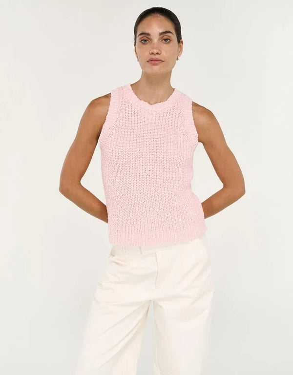 Woman wearing a STAPLE THE LABEL Cove Knit Tank in Rose Pink paired with white trousers.