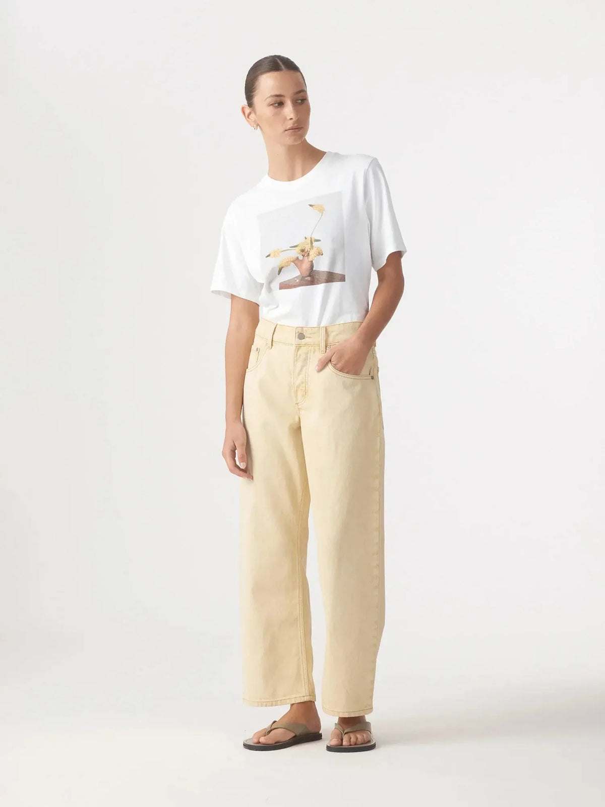 Woman wearing Nobody Denim Nadia Jean in Flax and a white graphic t-shirt.