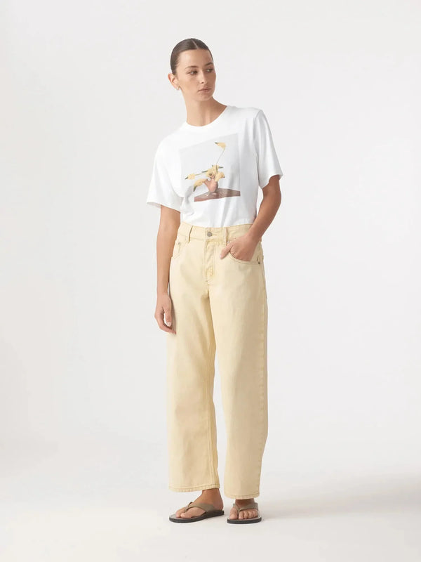 Woman wearing Nobody Denim Nadia Jean in Flax and a white graphic t-shirt.