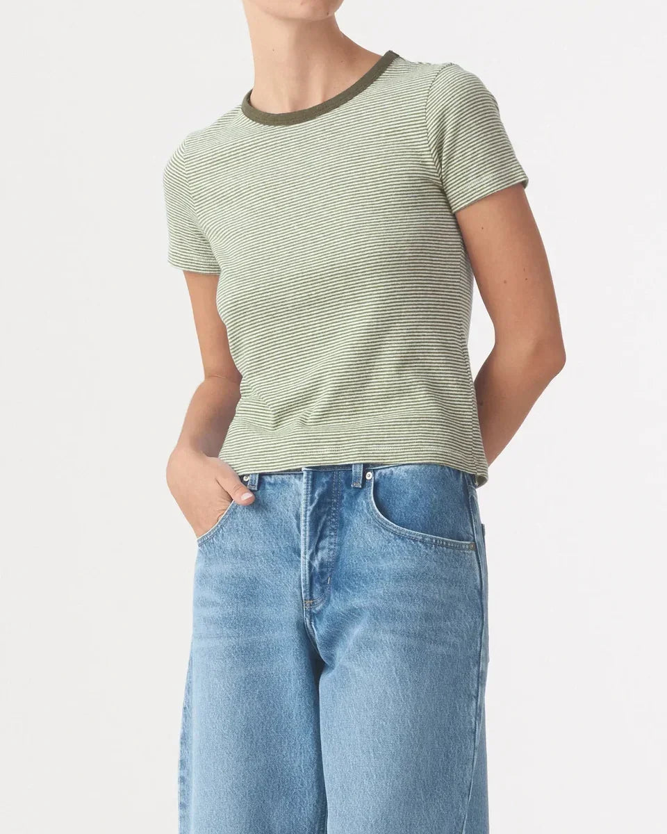 Woman wearing Nobody Denim Baby Tee in Olive Stripe paired with light blue jeans.