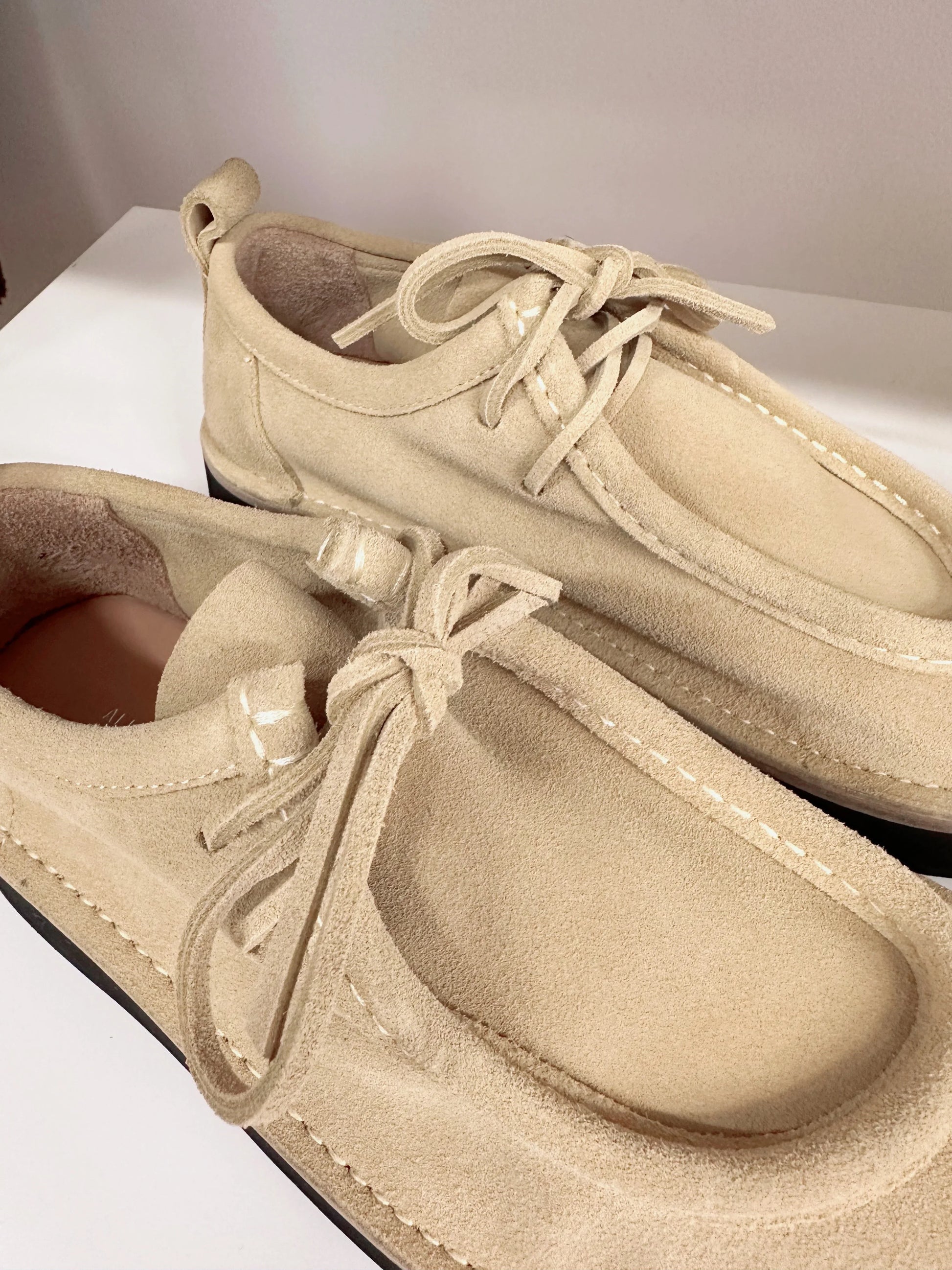 Beige suede women's lace-up shoes with white stitching, stylish and comfortable for casual wear.