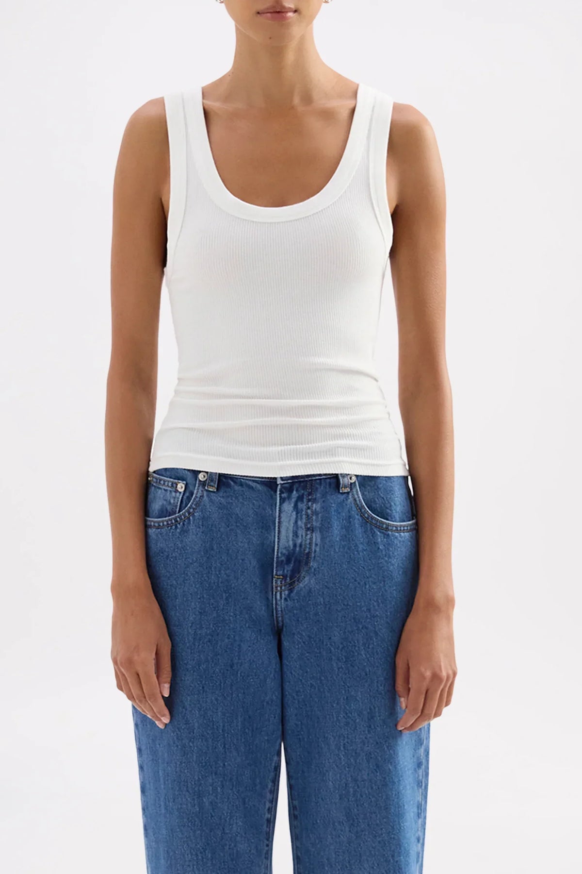 Woman wearing Nude Lucy Organic Rib Singlet in white paired with blue jeans