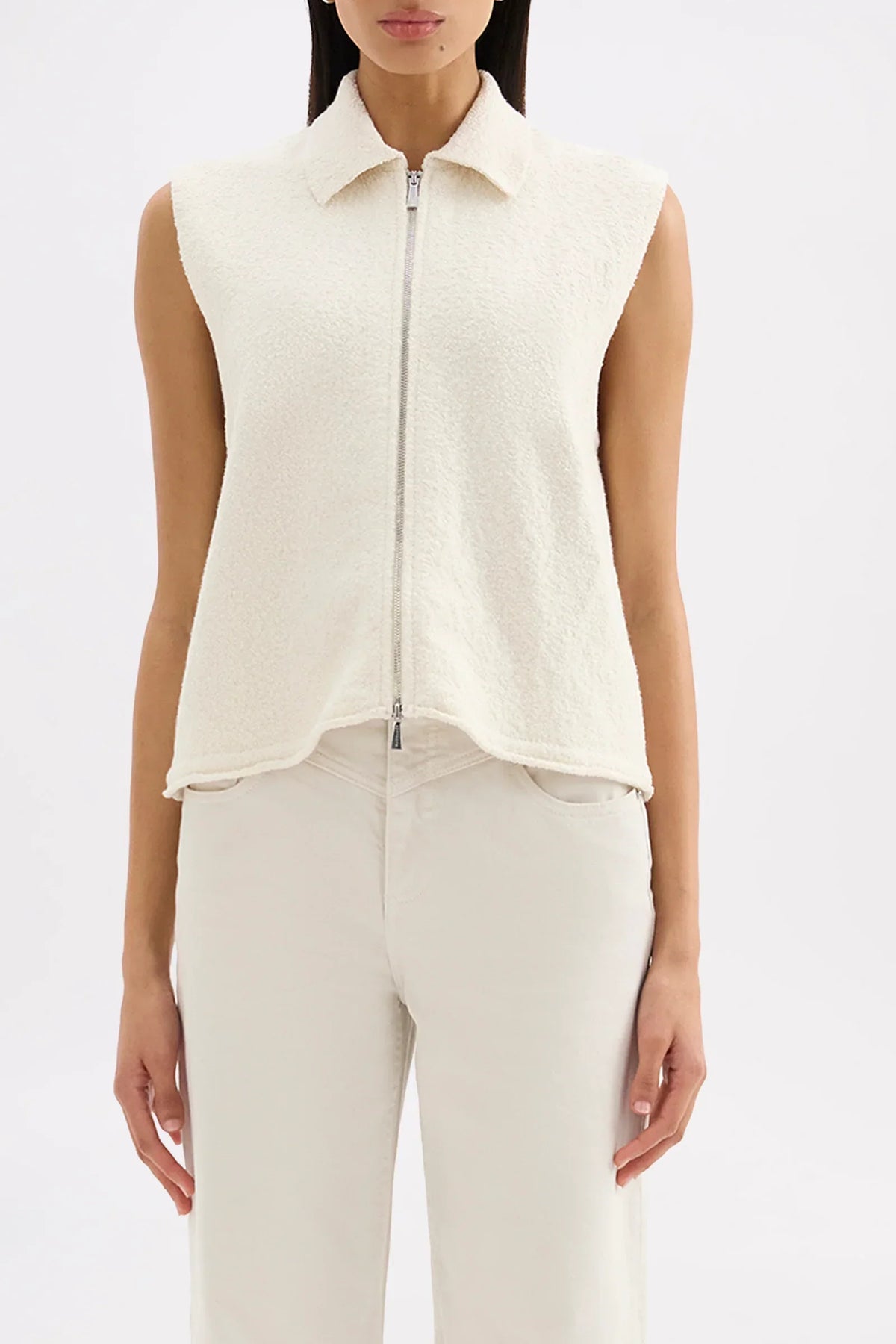 Woman wearing Nude Lucy Riella Knit Vest in Dune with cream pants
