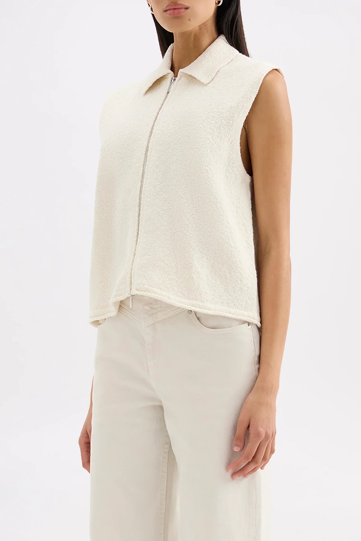 Woman wearing a Nude Lucy Riella Knit Vest in Dune with matching wide-leg trousers.