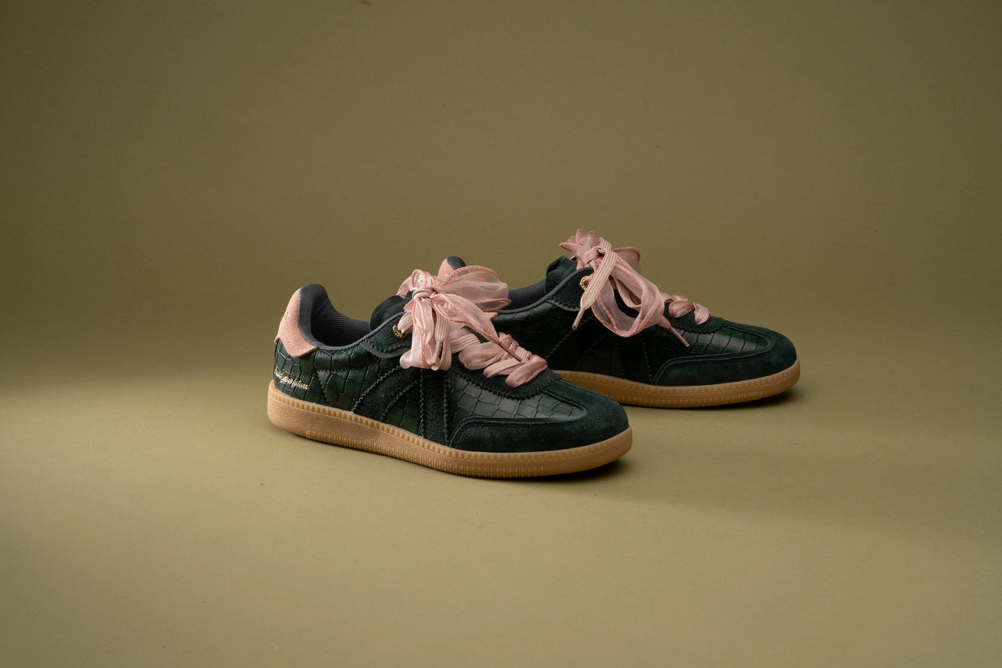 Dark green croc-texture sneakers with pink ribbon laces and gum soles, stylish everyday footwear