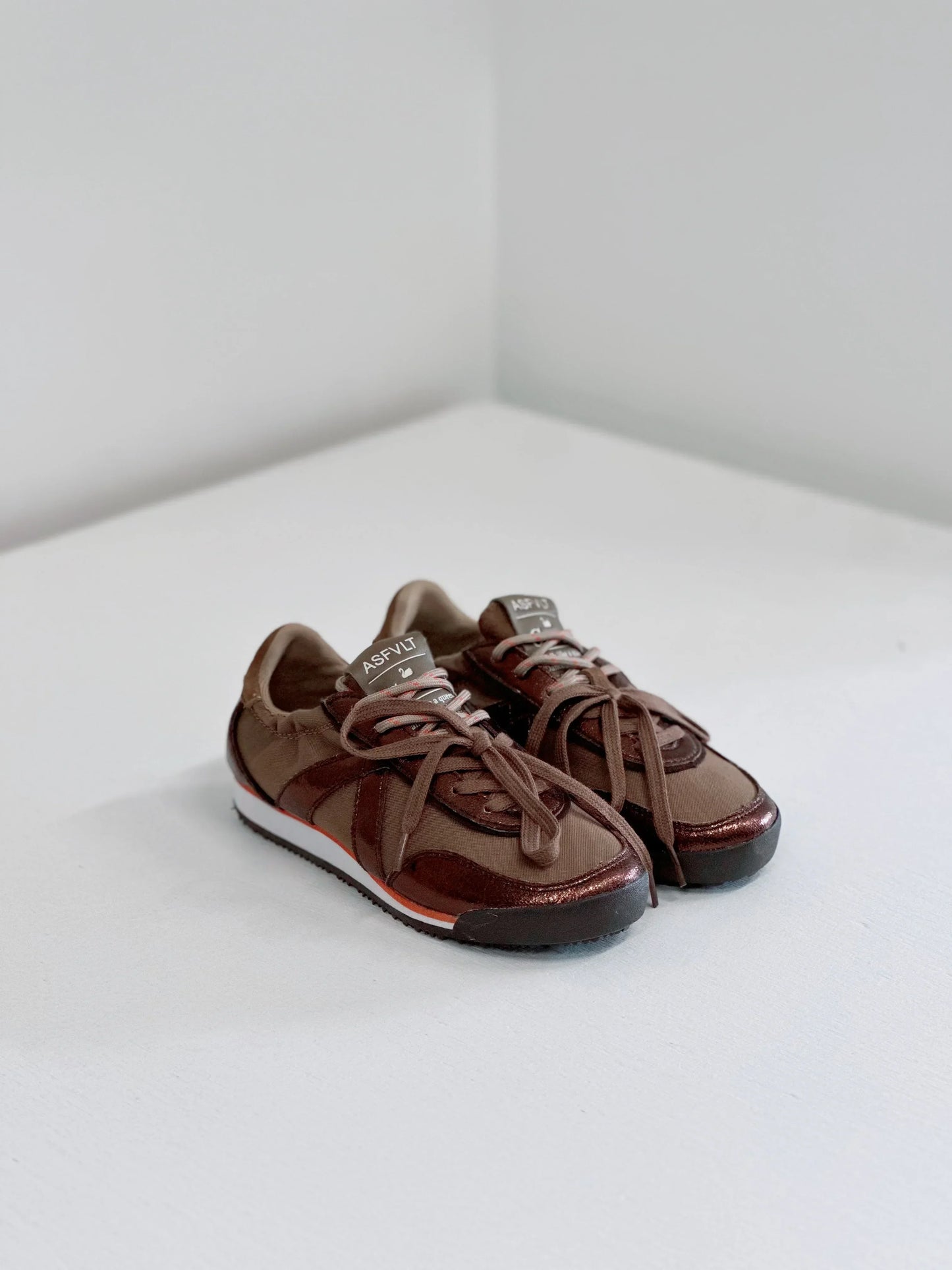 Brown ASFLVT sneakers with metallic accents and white soles, styled for everyday wear