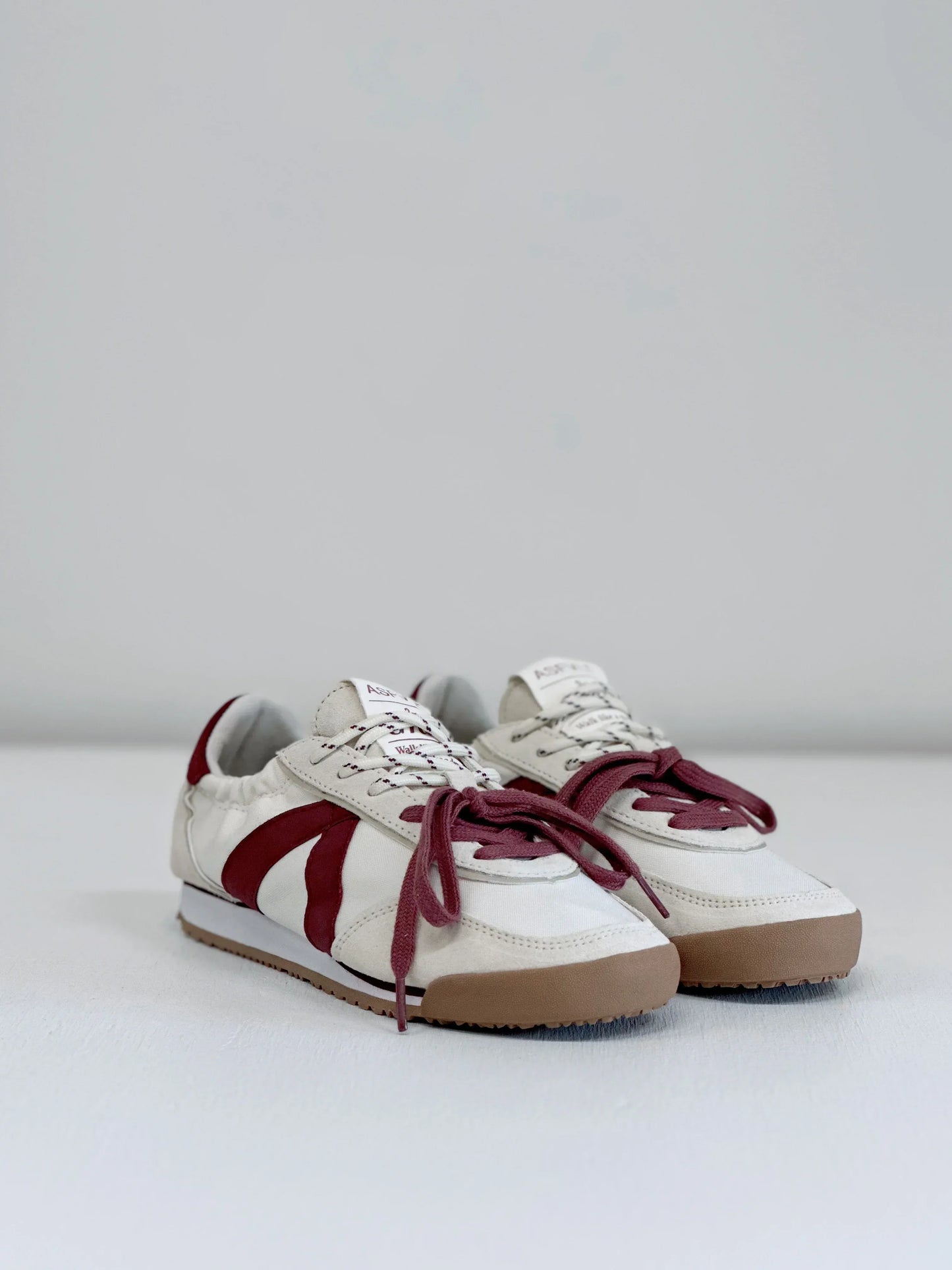 White sneakers with burgundy accents and gum soles, stylish everyday footwear