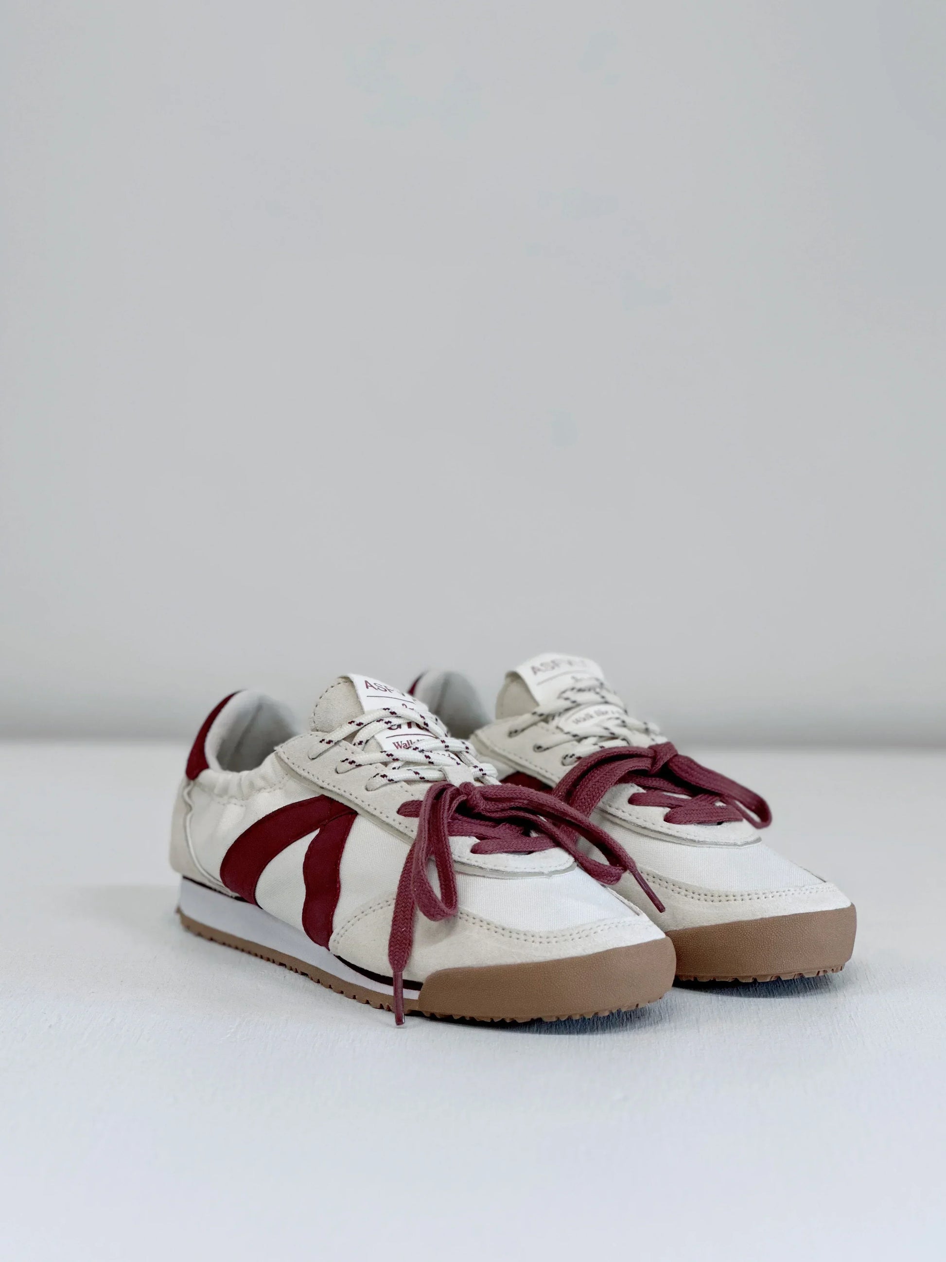 White sneakers with burgundy accents and gum soles, stylish everyday footwear