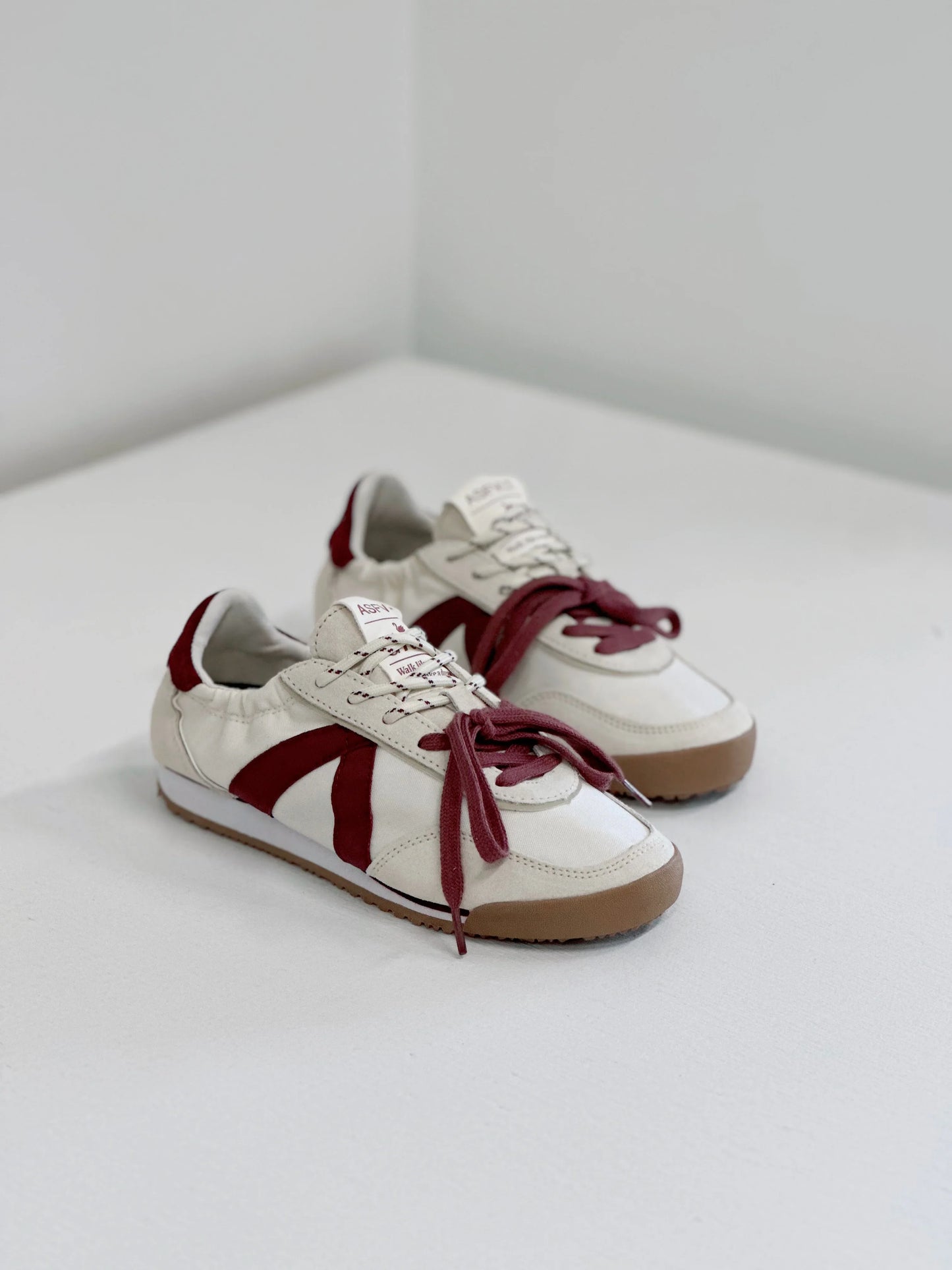 White sneakers with burgundy accents and laces, stylish everyday footwear
