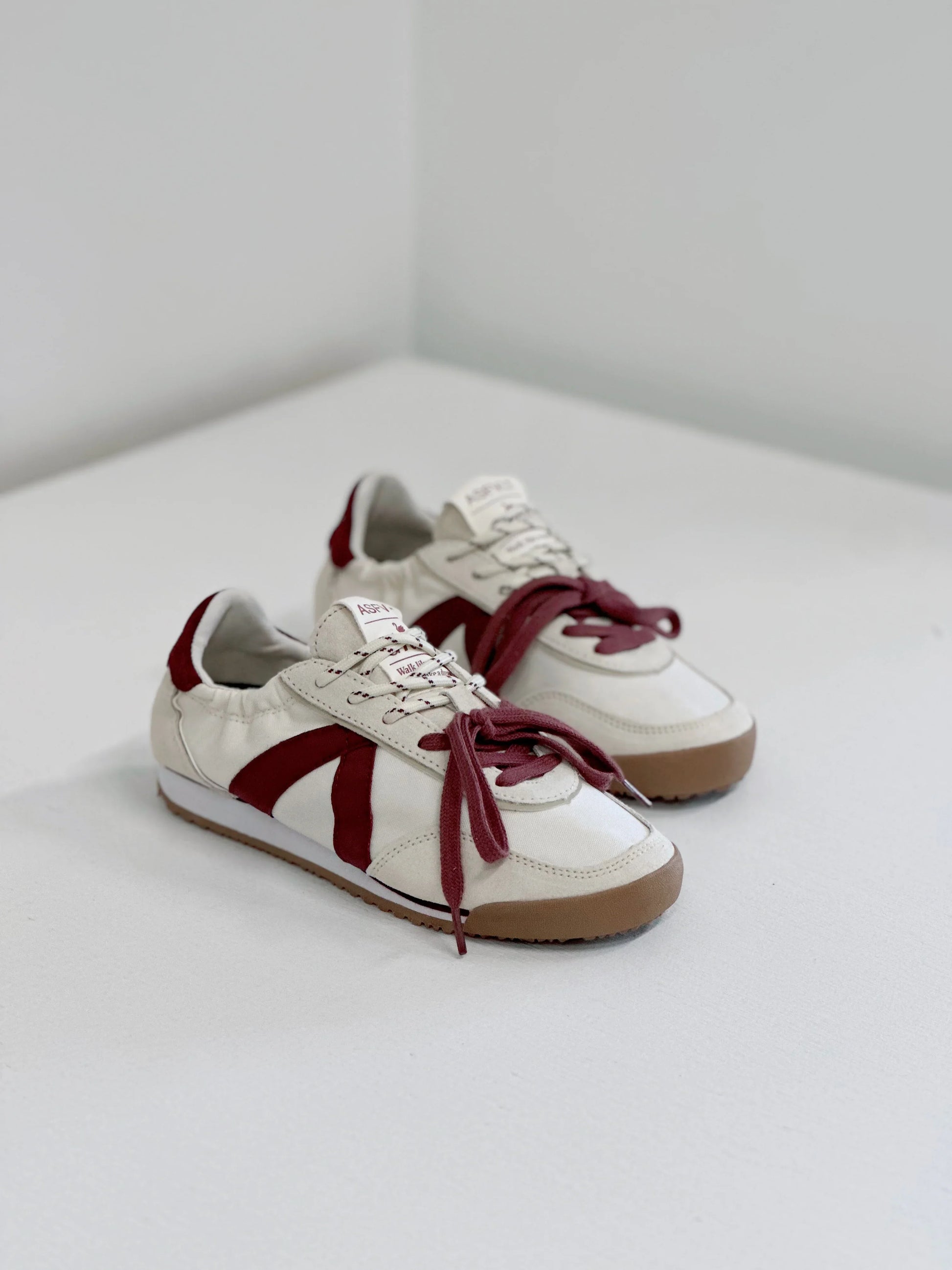 White sneakers with burgundy accents and laces, stylish everyday footwear