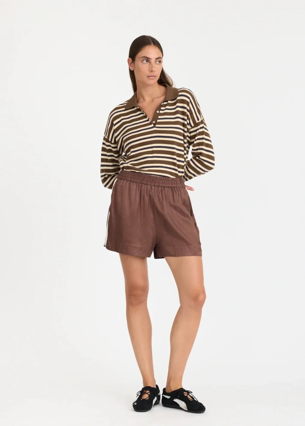 Woman in striped polo shirt and brown shorts, stylish casual outfit