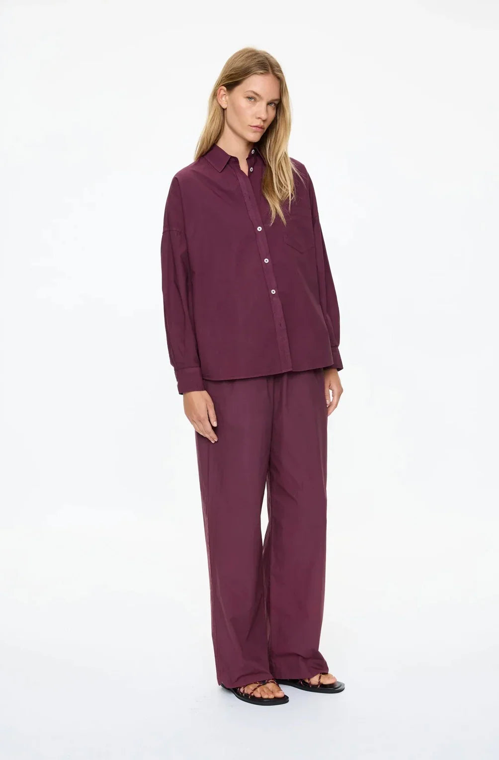 Woman in burgundy button-up shirt and wide-leg pants, stylish women's fashion set
