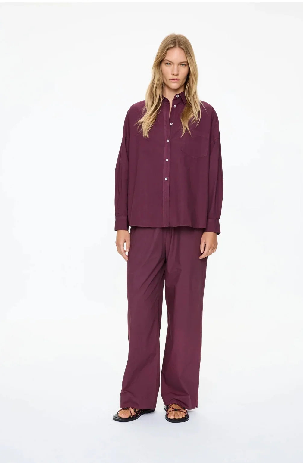 Woman in burgundy button-up shirt and wide-leg pants, casual women's fashion set