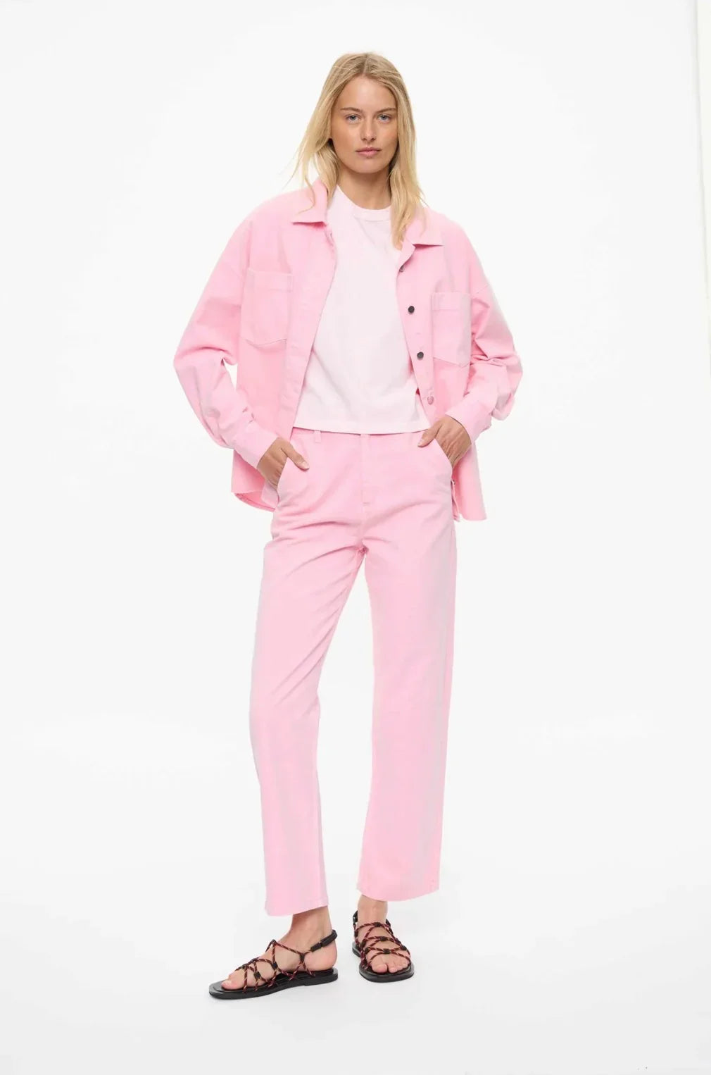 Pink women's fashion set with matching jacket and pants, styled with strappy sandals