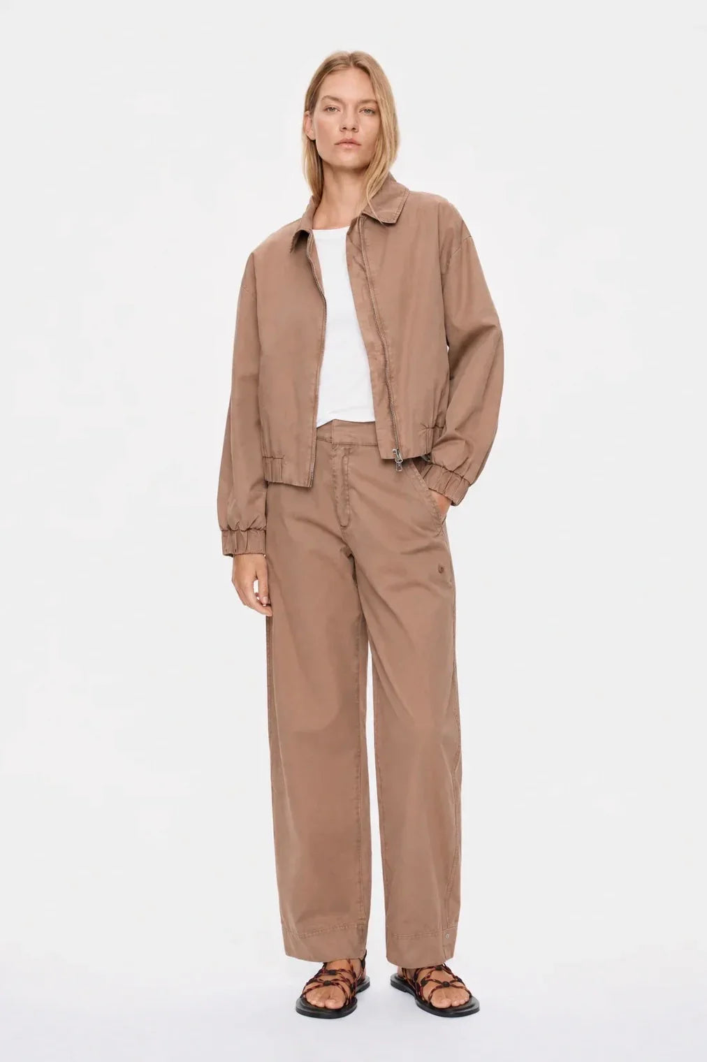Women's tan utility jacket and wide-leg pants outfit with strappy sandals