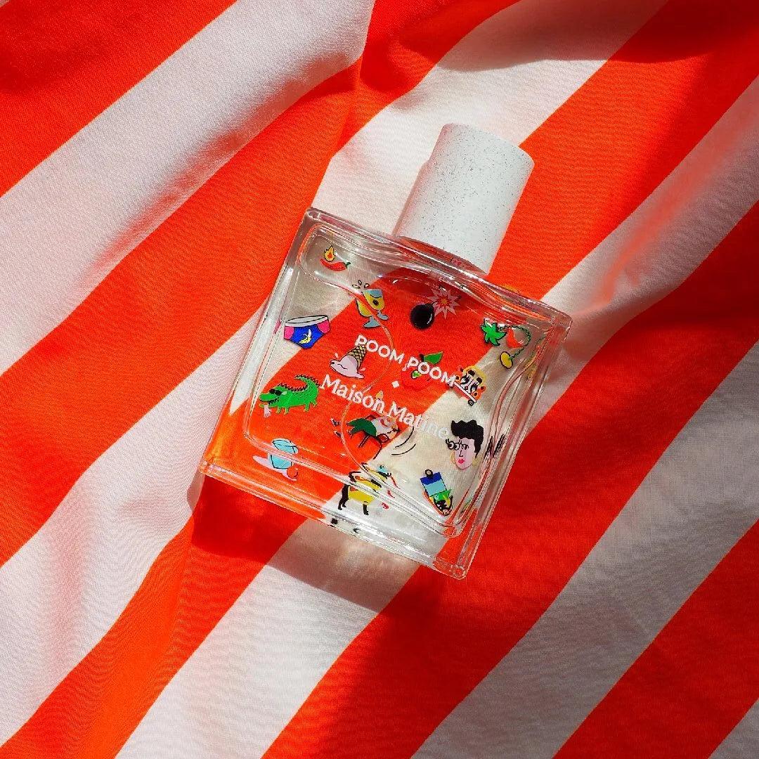 Maison Matine Poom Poom perfume bottle with playful stickers on orange and white stripes