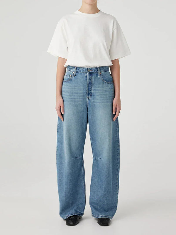 Wide-leg blue jeans paired with white t-shirt and black shoes for casual women's fashion