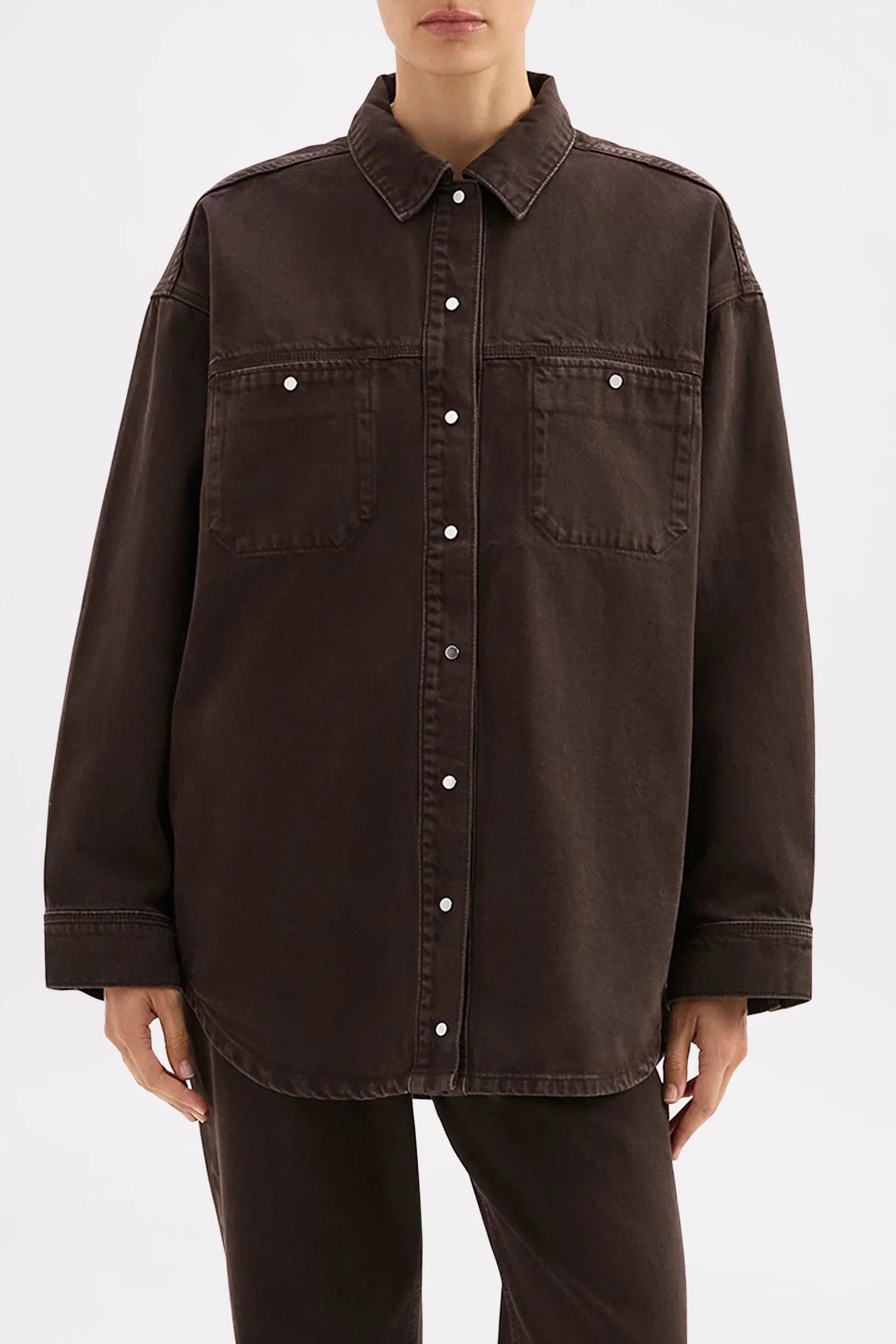 Dark brown oversized button-up shirt with chest pockets, styled for modern women's fashion