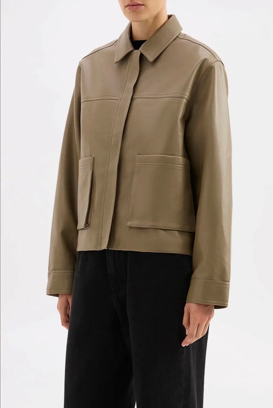 Olive green vegan leather jacket with collar and front pockets, styled with black pants for women's fashion