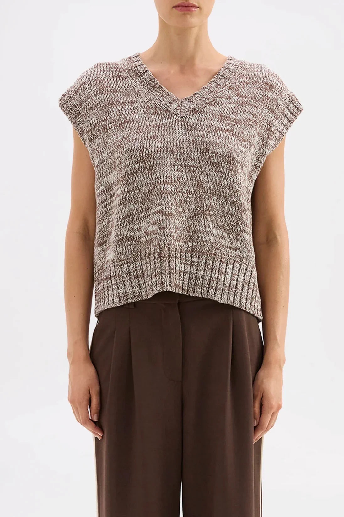 Women's marled knit V-neck sleeveless top with ribbed hem, paired with brown pleated trousers