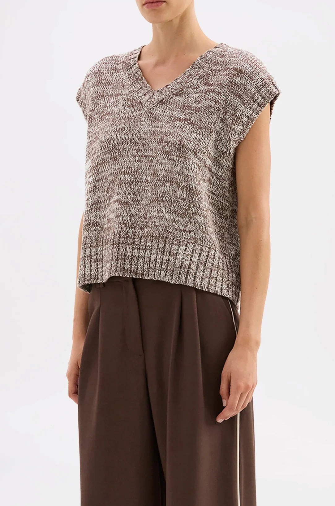Women's marled knit V-neck sleeveless top with ribbed hem, paired with wide-leg brown trousers