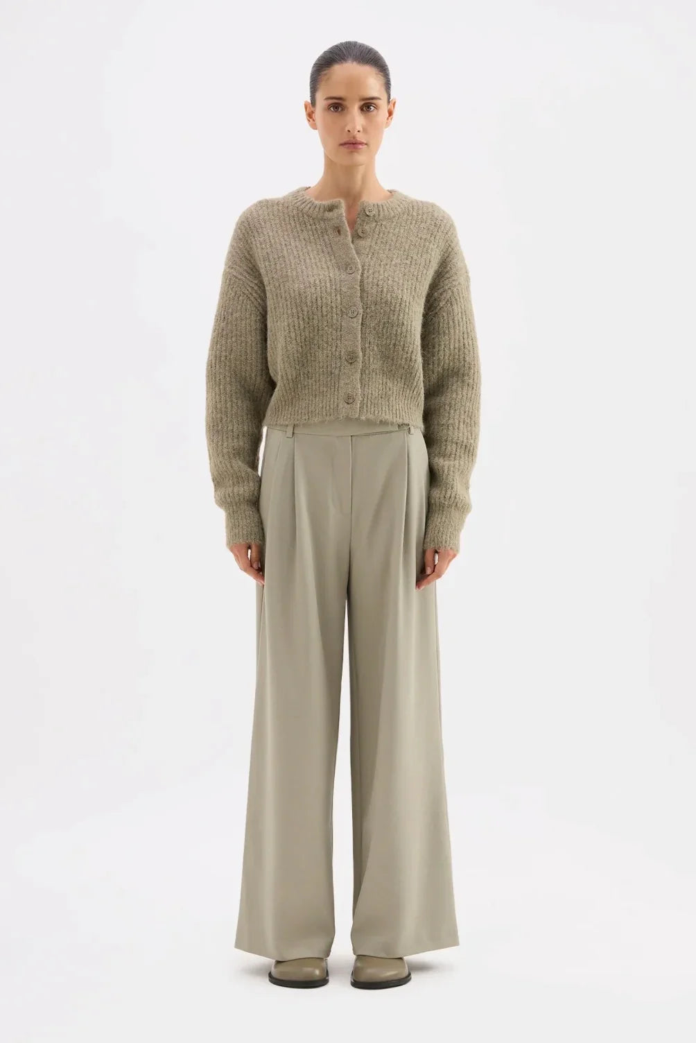 Woman in cozy olive cardigan and wide-leg trousers, modern women's fashion outfit