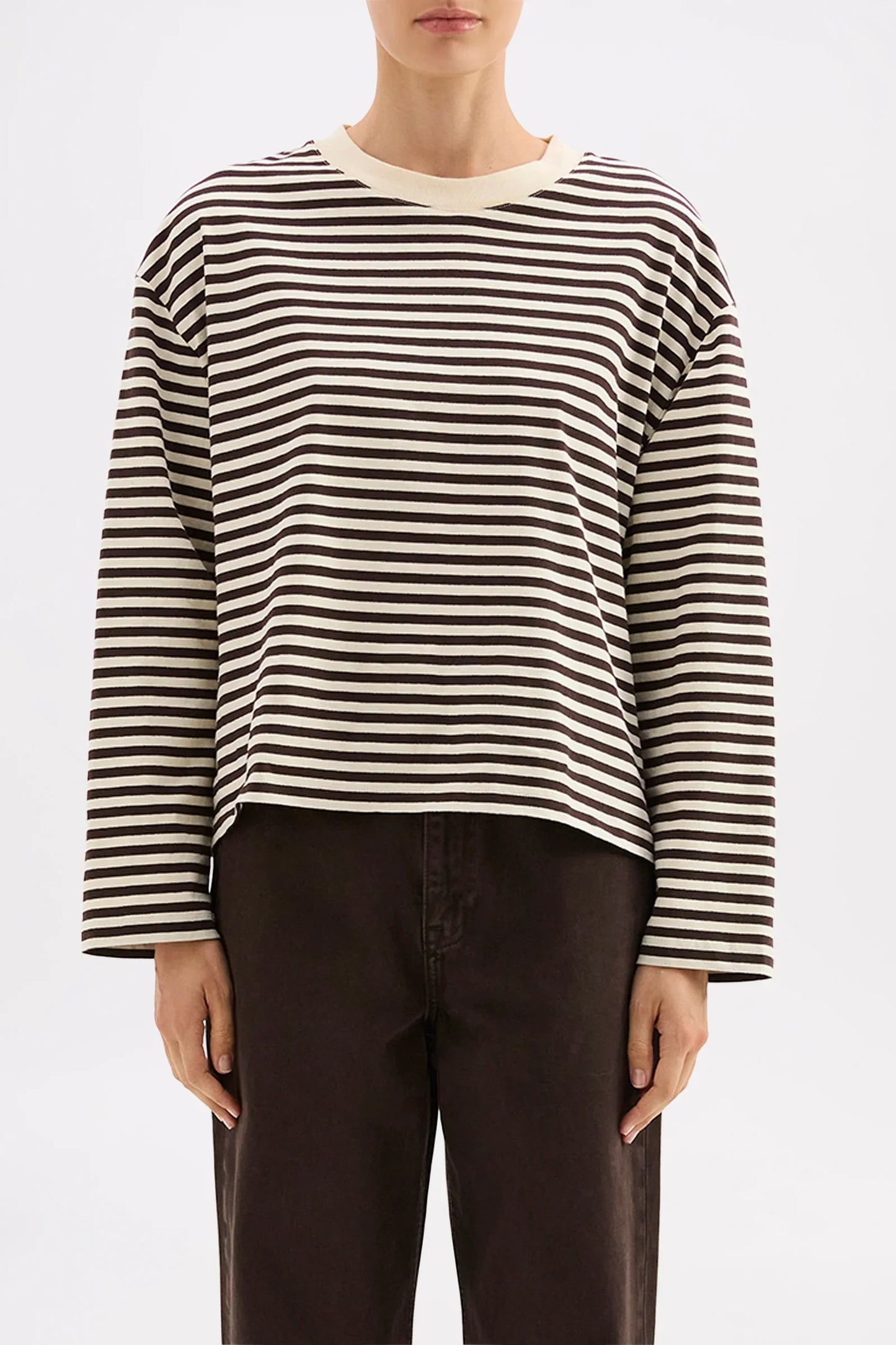 Striped long-sleeve top with relaxed fit, paired with dark pants for casual chic style