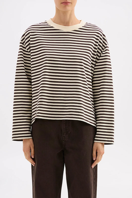 Striped long-sleeve top with relaxed fit, paired with dark pants for casual chic style