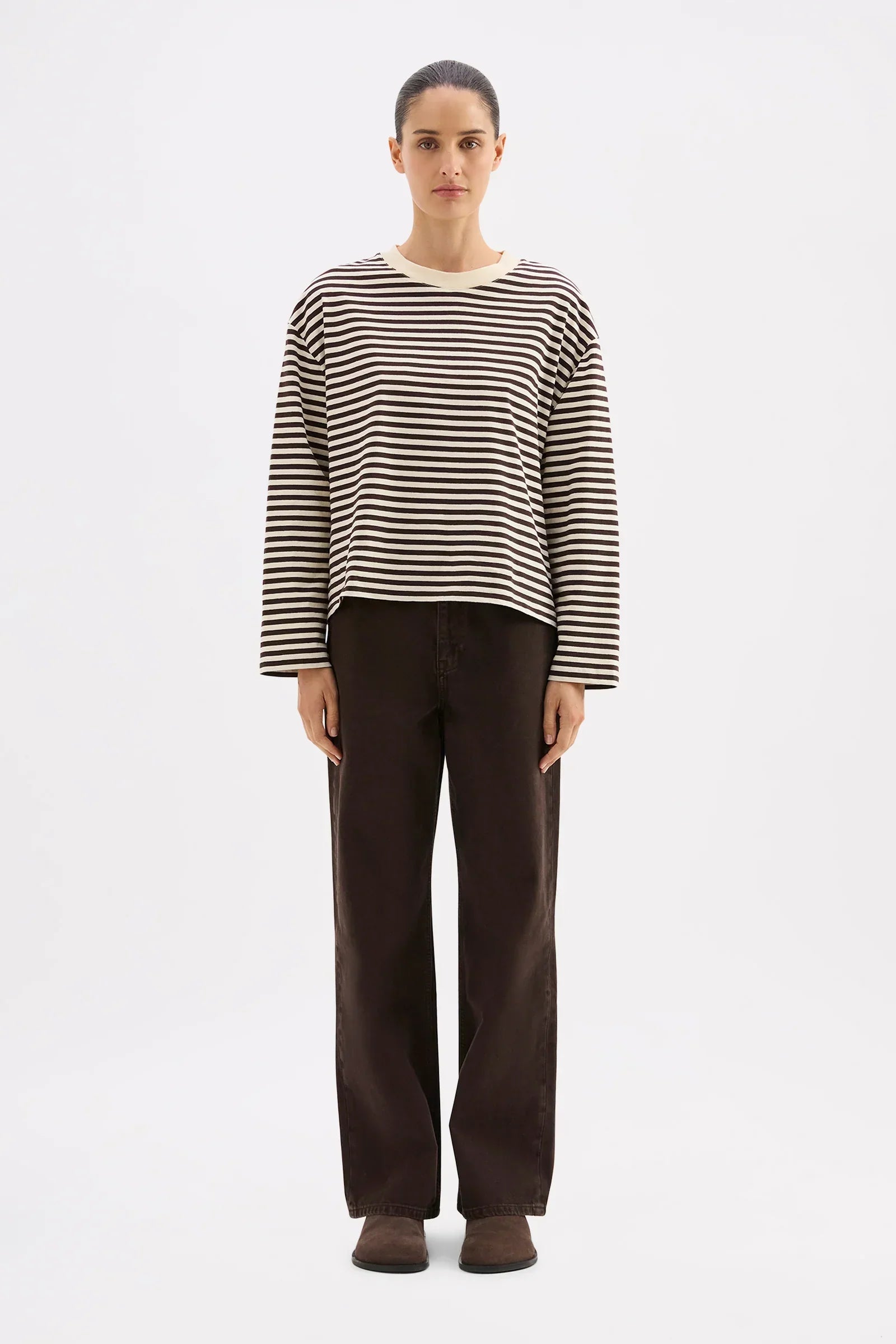 Woman wearing striped long sleeve top and dark wide-leg pants, stylish casual outfit