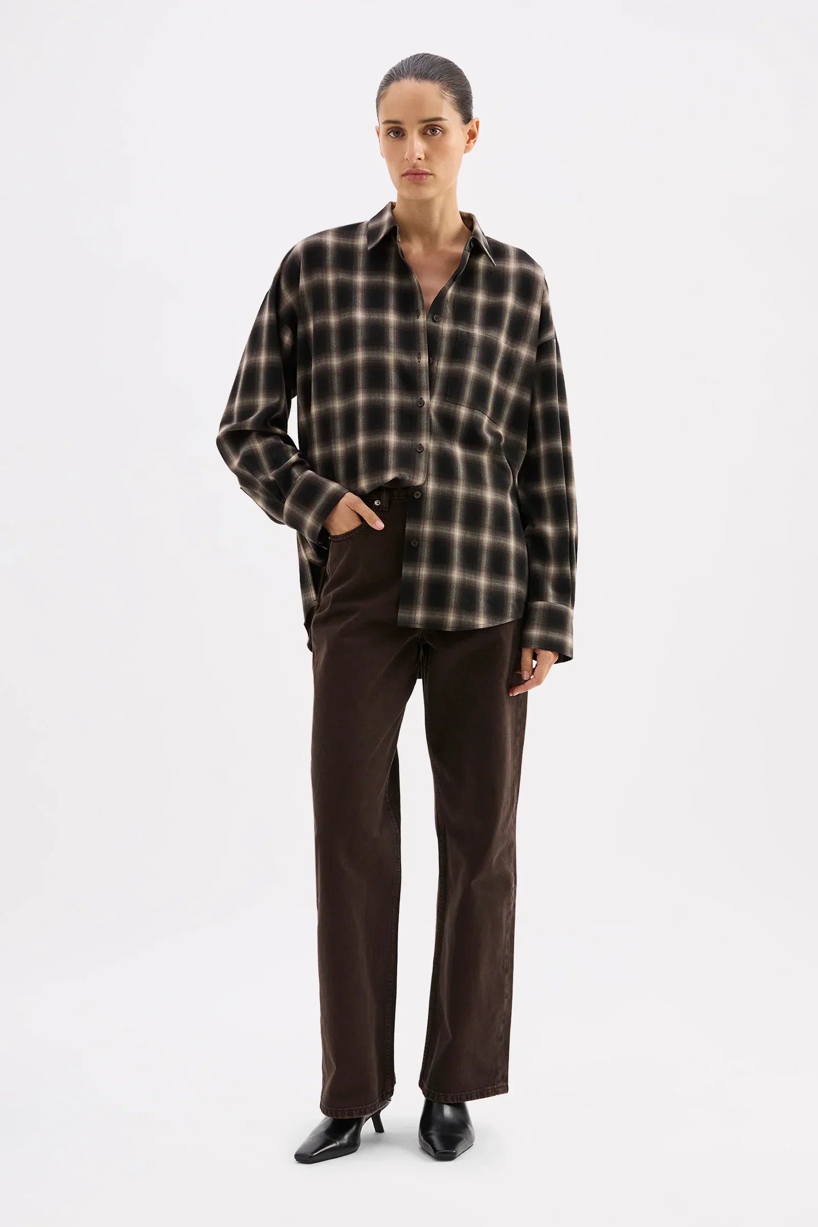 Woman in black and beige plaid shirt with dark brown wide-leg pants and black heels, stylish casual outfit