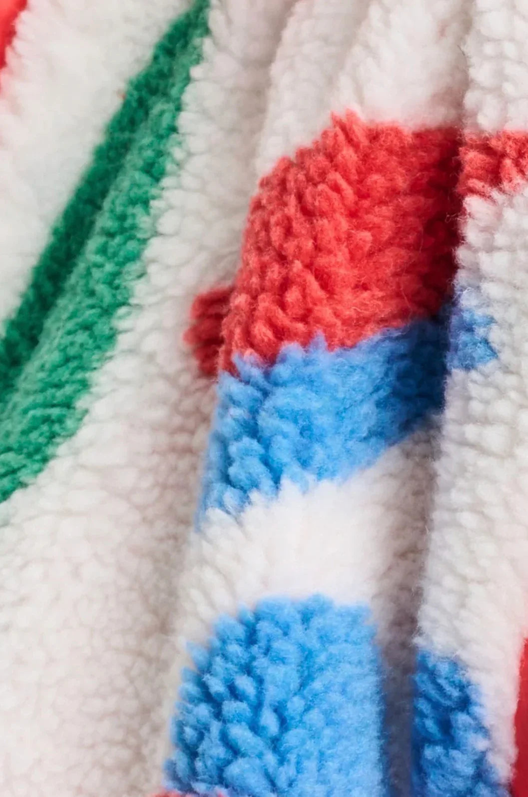 Soft, colourful sherpa blanket with red, blue, green, and white stripes for cozy comfort