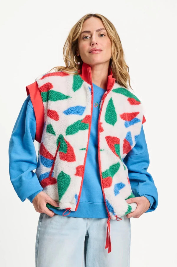 POM Amsterdam geometric print fleece vest over blue sweatshirt, styled with light wash jeans for casual chic look