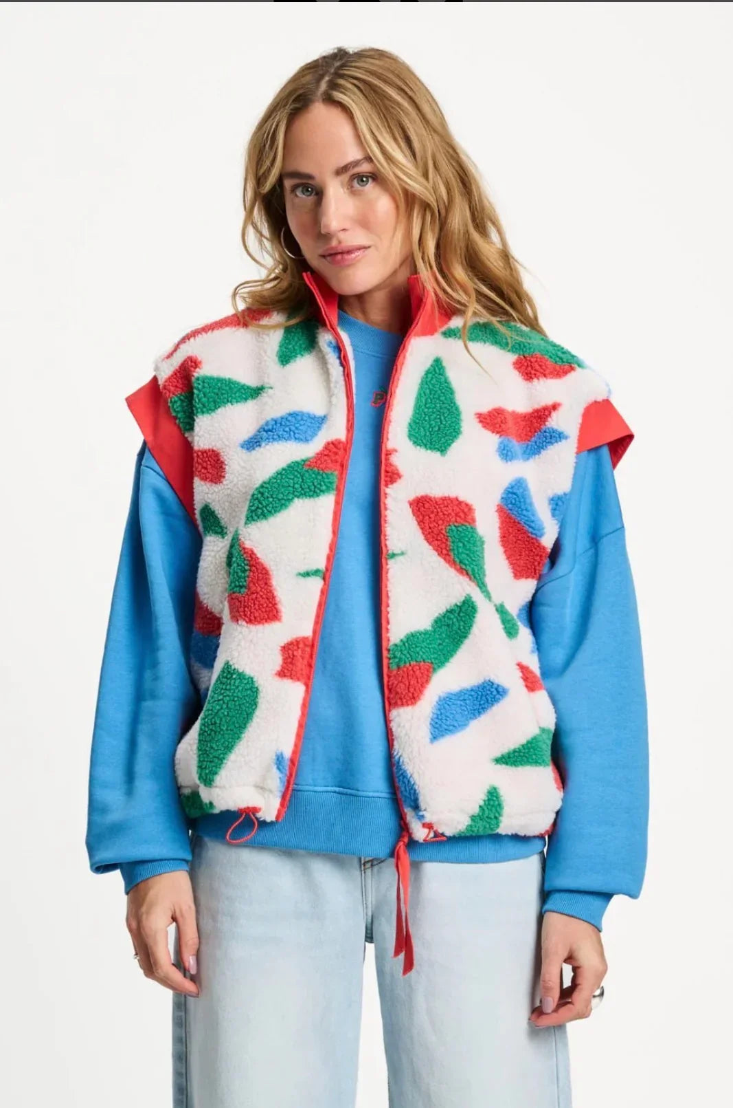 abstract patterned Teddy fleece vest over blue sweatshirt, styled with light jeans for casual chic look