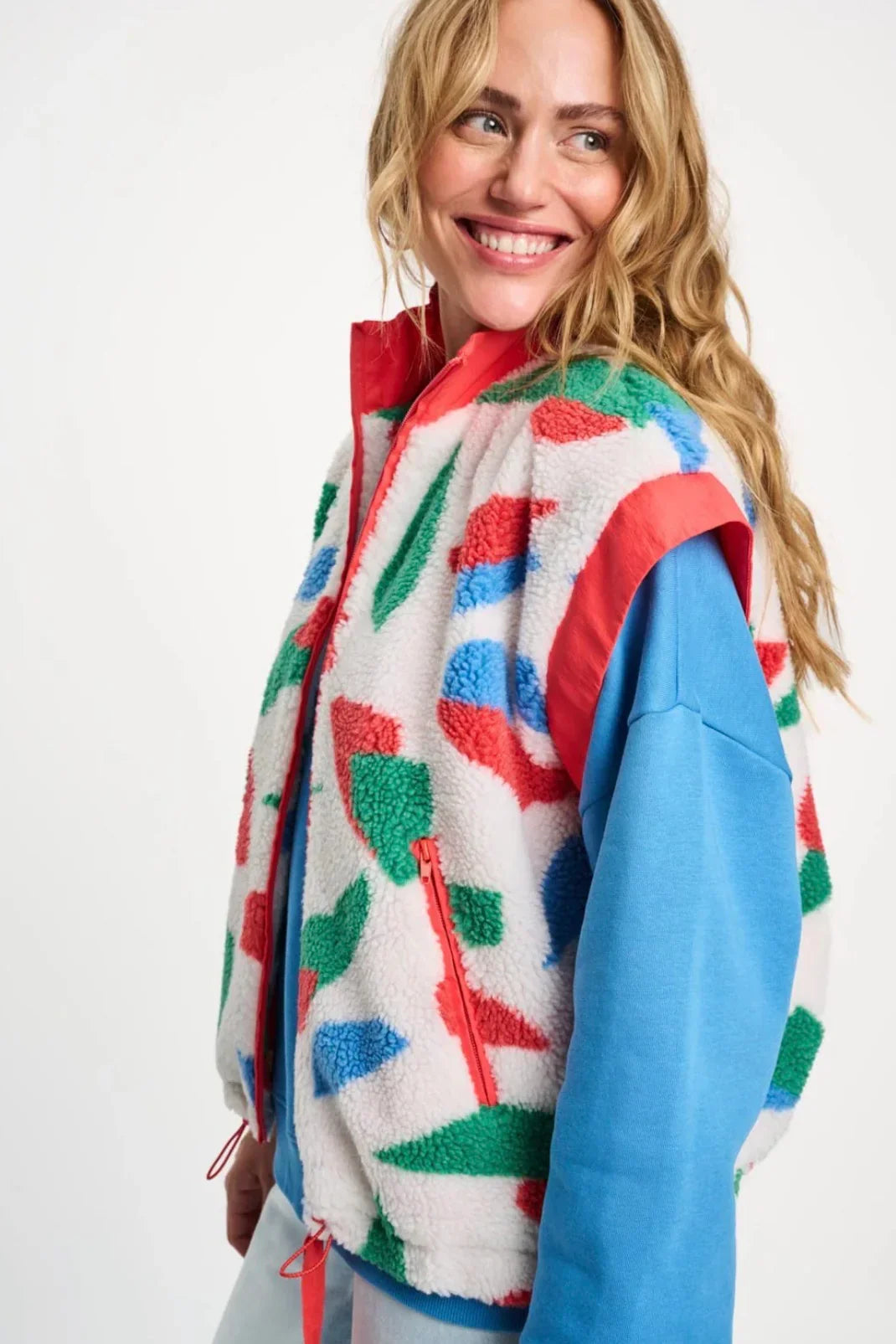 Colourful geometric print fleece jacket with red zipper, blue sleeves, and cozy texture for women's fashion