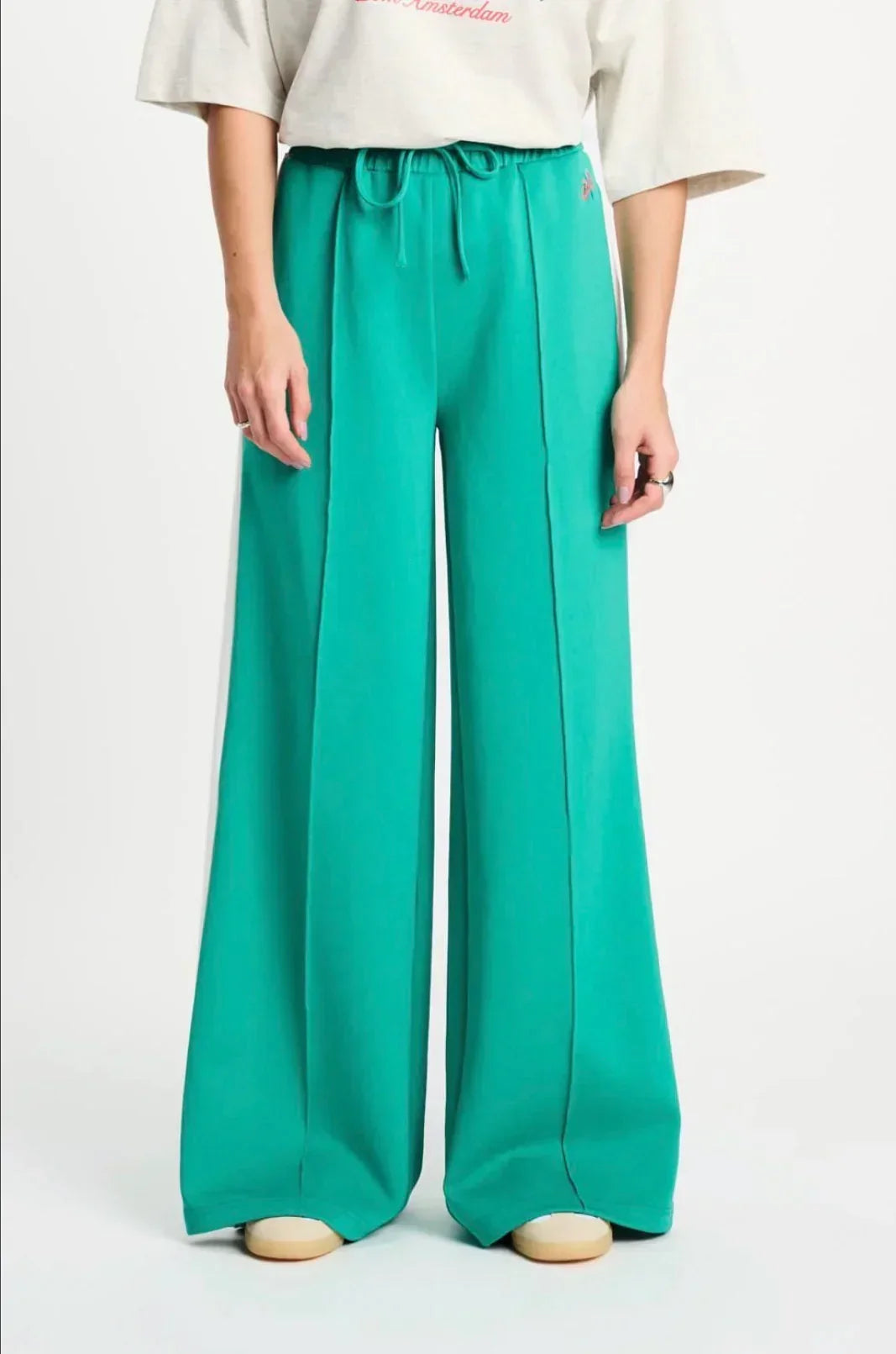 POM Amsterdam Emerald green wide-leg drawstring pants with side pockets, styled with a relaxed-fit tee for casual chic.