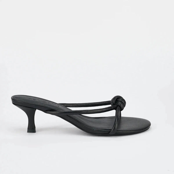 Black leather mule sandal with knot detail and low heel on white background