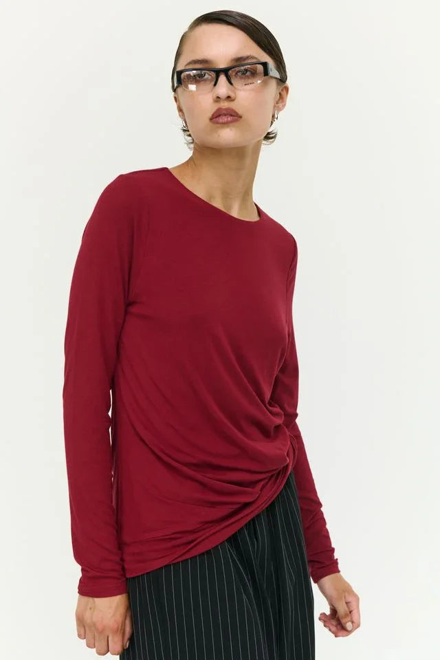 Red long-sleeve twist-front top paired with pinstripe pants for women's fashion